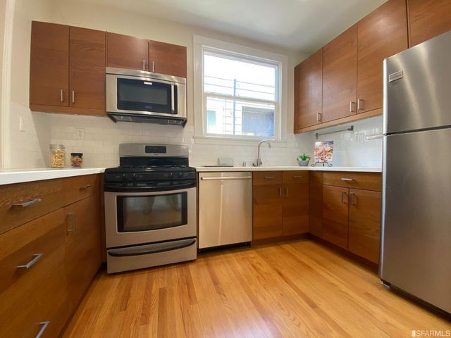 a living room with furniture dining table wooden floor and a large window