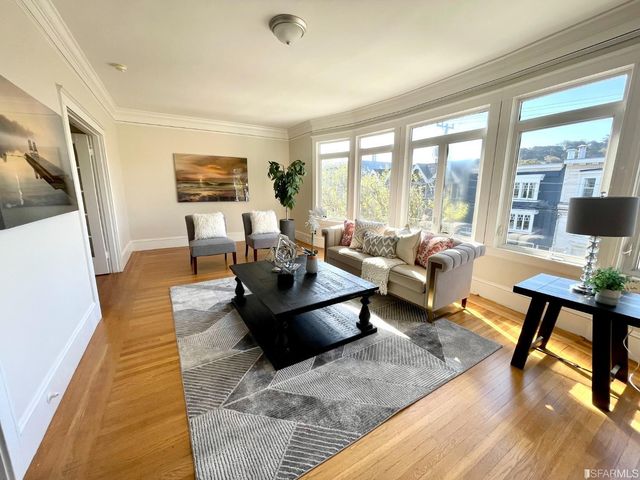 a living room with furniture potted plant and a large window