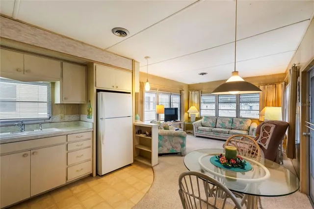 a kitchen with stainless steel appliances granite countertop a stove a sink dishwasher a dining table and chairs with wooden floor