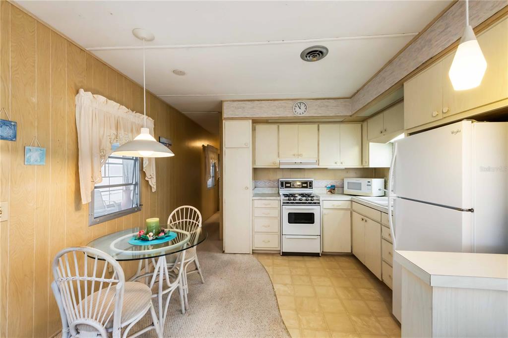 239 Inner Drive East Venice, FL 34285 - Photo 13 of 48 a kitchen with stainless steel appliances granite countertop a refrigerator a stove a sink dishwasher and white cabinets with wooden floor