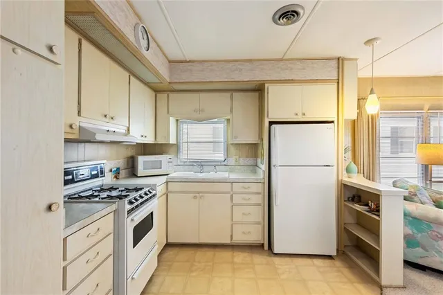 a kitchen with stainless steel appliances granite countertop a refrigerator sink and stove