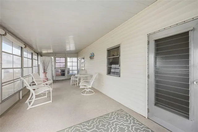 a work room with furniture a flat screen tv and a large window