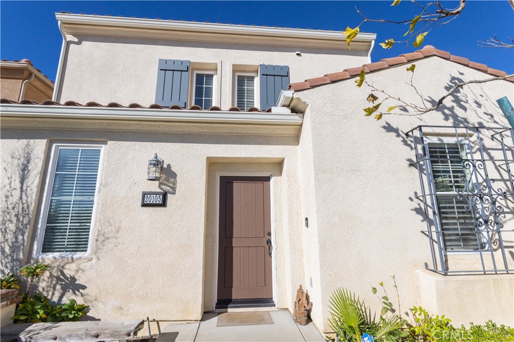 20105 Livorno Way, Unit 212 Porter Ranch, CA 91326 - Photo 1 of 1 a view of front door and potted plants
