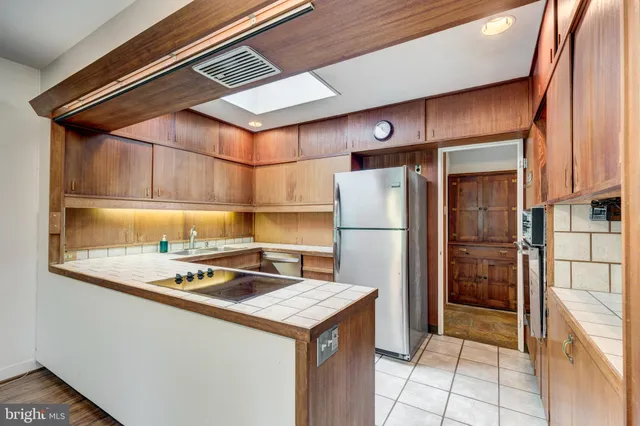 a view of kitchen with stainless steel appliances granite countertop refrigerator sink and cabinets