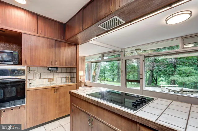 a living room with furniture potted plant chandelier and a large window
