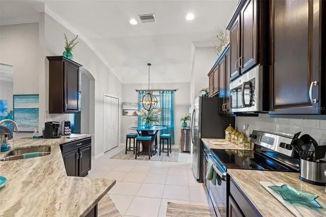 a kitchen with stainless steel appliances granite countertop a refrigerator a stove and a sink