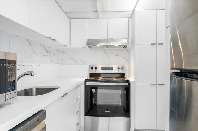 a kitchen with stainless steel appliances a sink and a refrigerator
