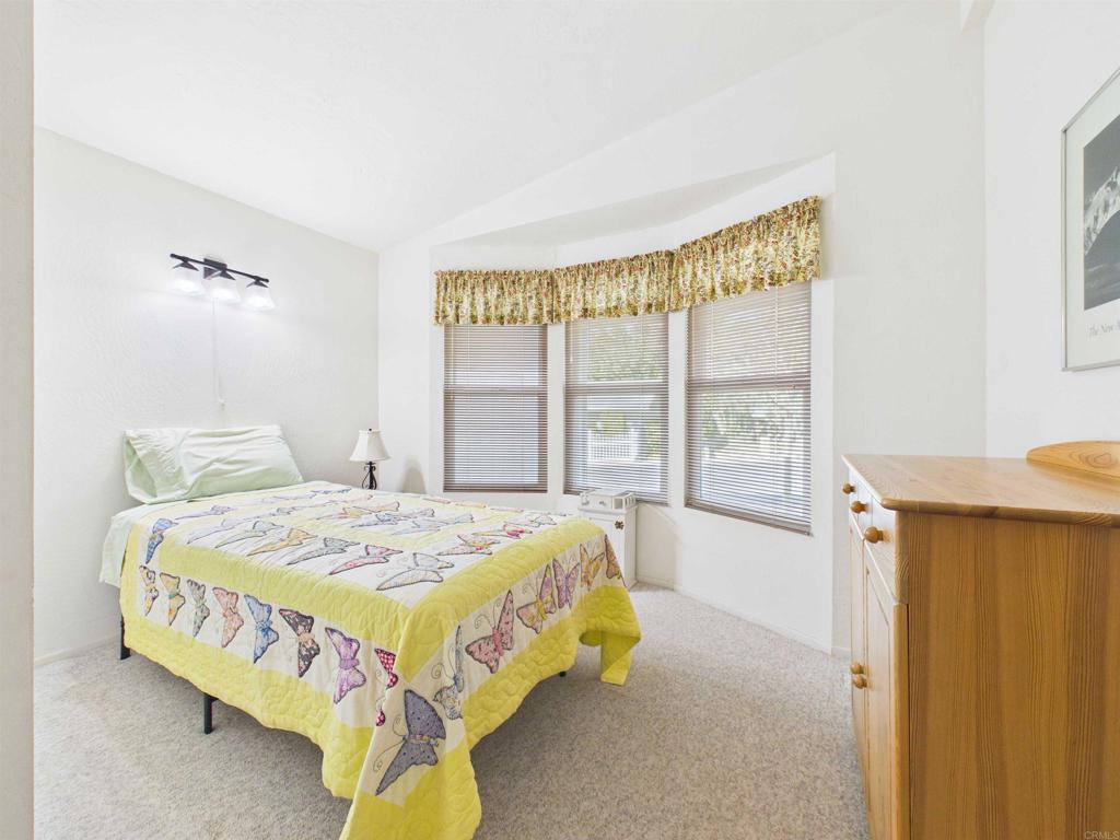18218 Paradise Mountain Road, Unit 220 Valley Center, CA 92082 - Photo 34 of 48 a bed sitting in a bedroom next to a window