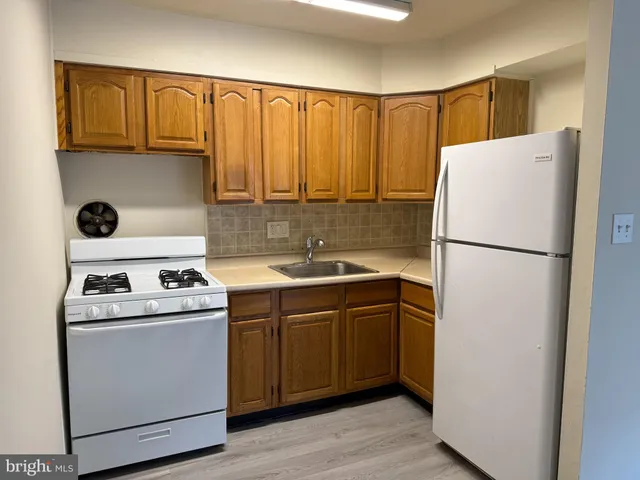 a kitchen with a refrigerator sink and cabinets