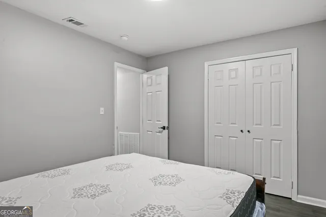 a bedroom with a bed and wooden floor