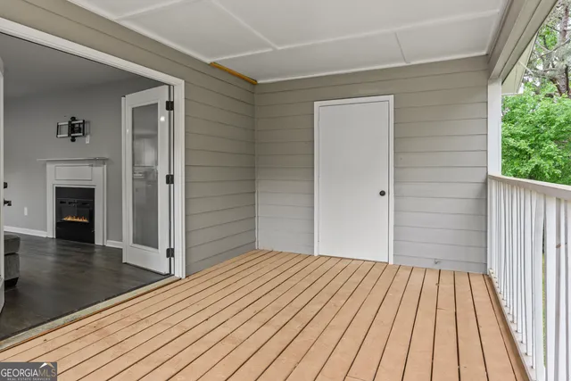 an empty room with wooden floor a fireplace and windows