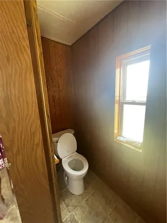 a white toilet sitting next to a window and a sink