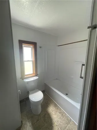 a bathroom with a toilet and a shower