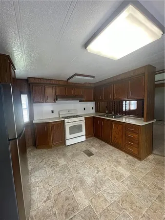 a kitchen with stainless steel appliances granite countertop a stove a sink and a refrigerator