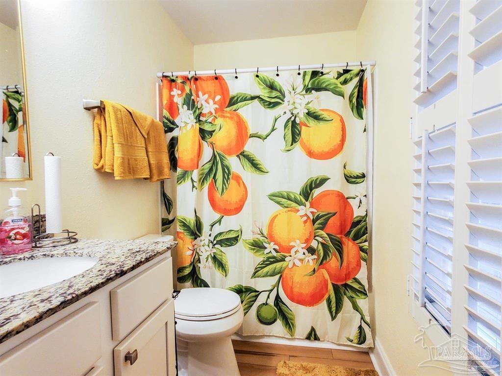 601 East Burgess Road, Unit E4 Pensacola, FL 32504 - Photo 11 of 18 a bathroom with a sink mirror vanity and toilet