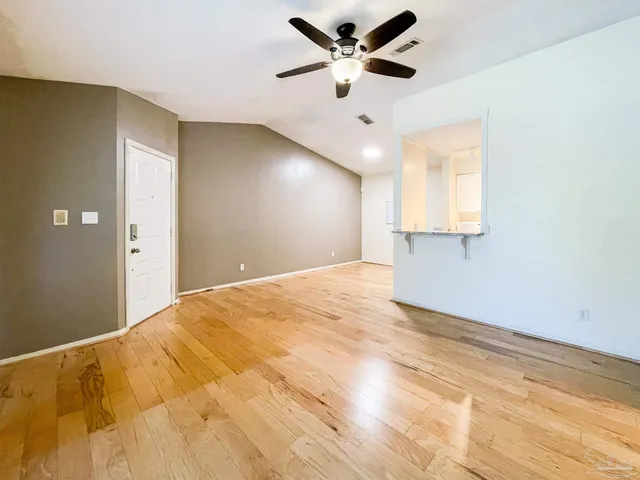 a view of a big room with wooden floor and a ceiling fan