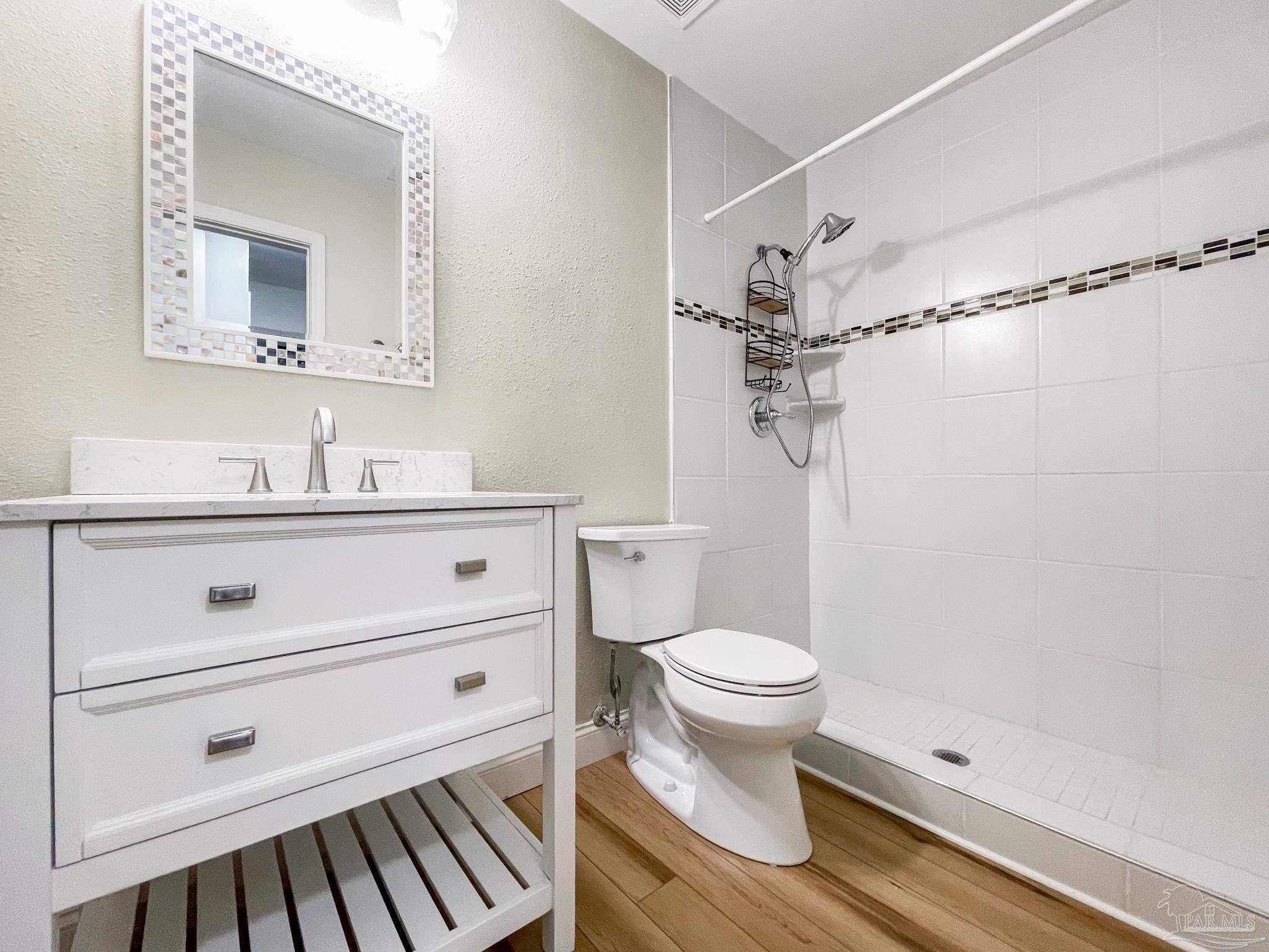 601 East Burgess Road, Unit E4 Pensacola, FL 32504 - Photo 5 of 18 a bathroom with a sink toilet a mirror and shower
