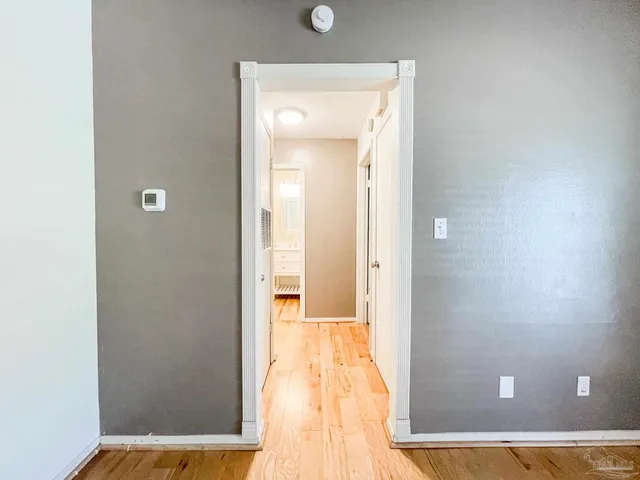 a view of a hallway with wooden floor