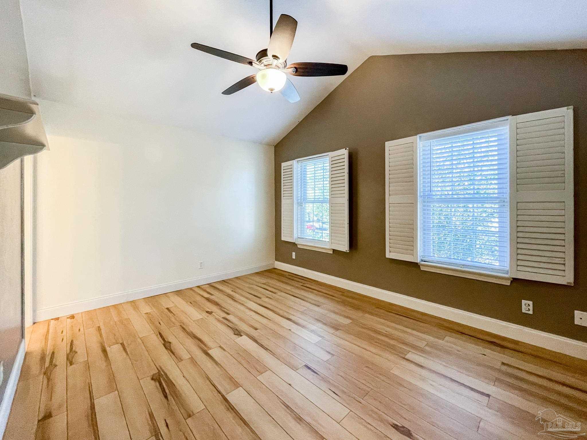 601 East Burgess Road, Unit E4 Pensacola, FL 32504 - Photo 7 of 18 a view of an empty room with a window and wooden floor