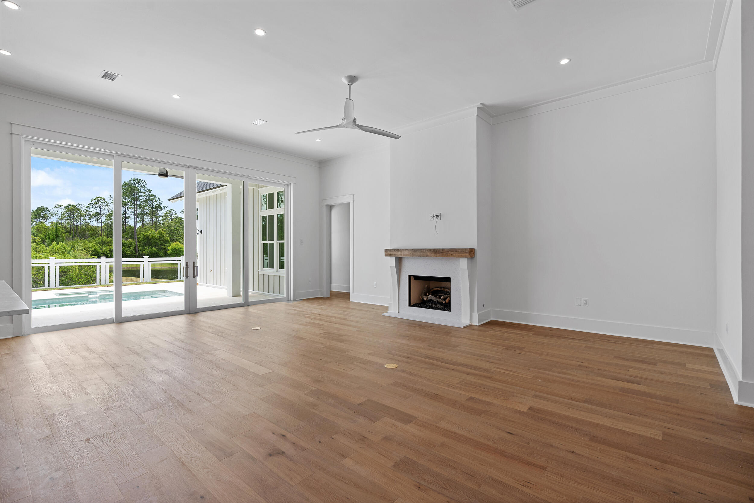 129 Pollard Cove West, Unit LOT 58 Watersound, FL 32461 - Photo 6 of 39 a view of empty room with wooden floor and fireplace