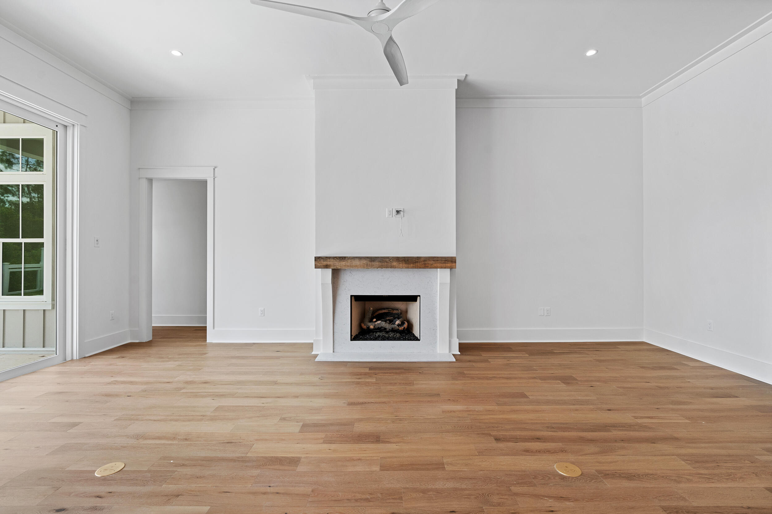 129 Pollard Cove West, Unit LOT 58 Watersound, FL 32461 - Photo 9 of 39 a view of an empty room with wooden floor fireplace and a window