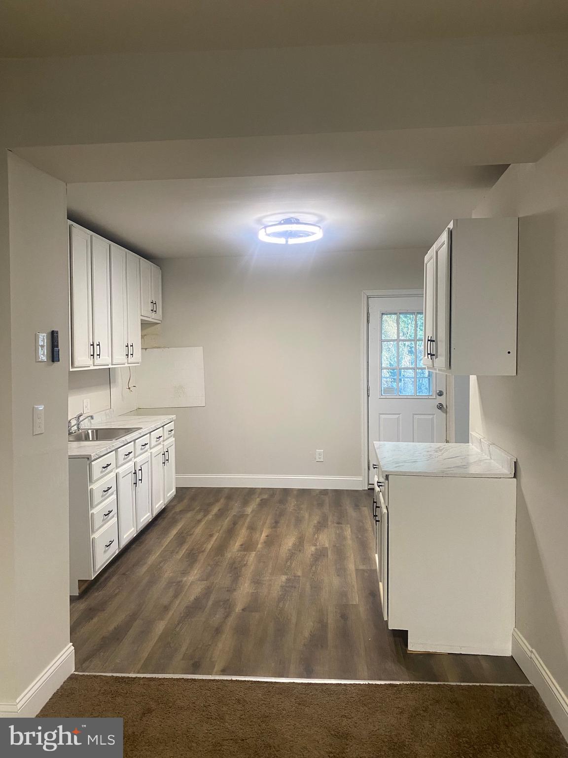 724 East 35th Street Baltimore, MD 21218 - Photo 6 of 13 a kitchen with granite countertop a sink cabinets and wooden floor