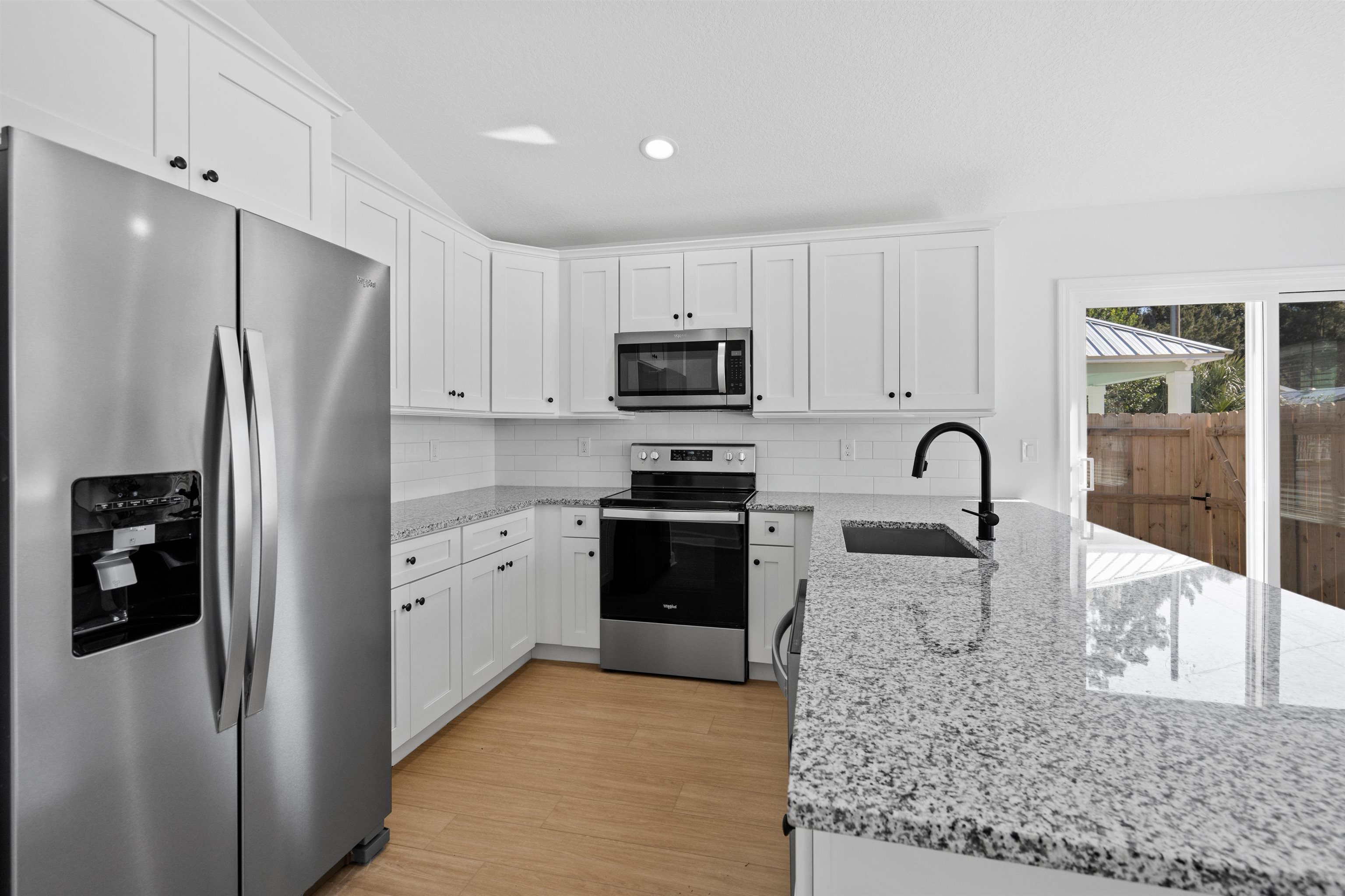 79 Helen Street St. Augustine, FL 32084 - Photo 6 of 33 a kitchen with granite countertop a refrigerator and a stove top oven