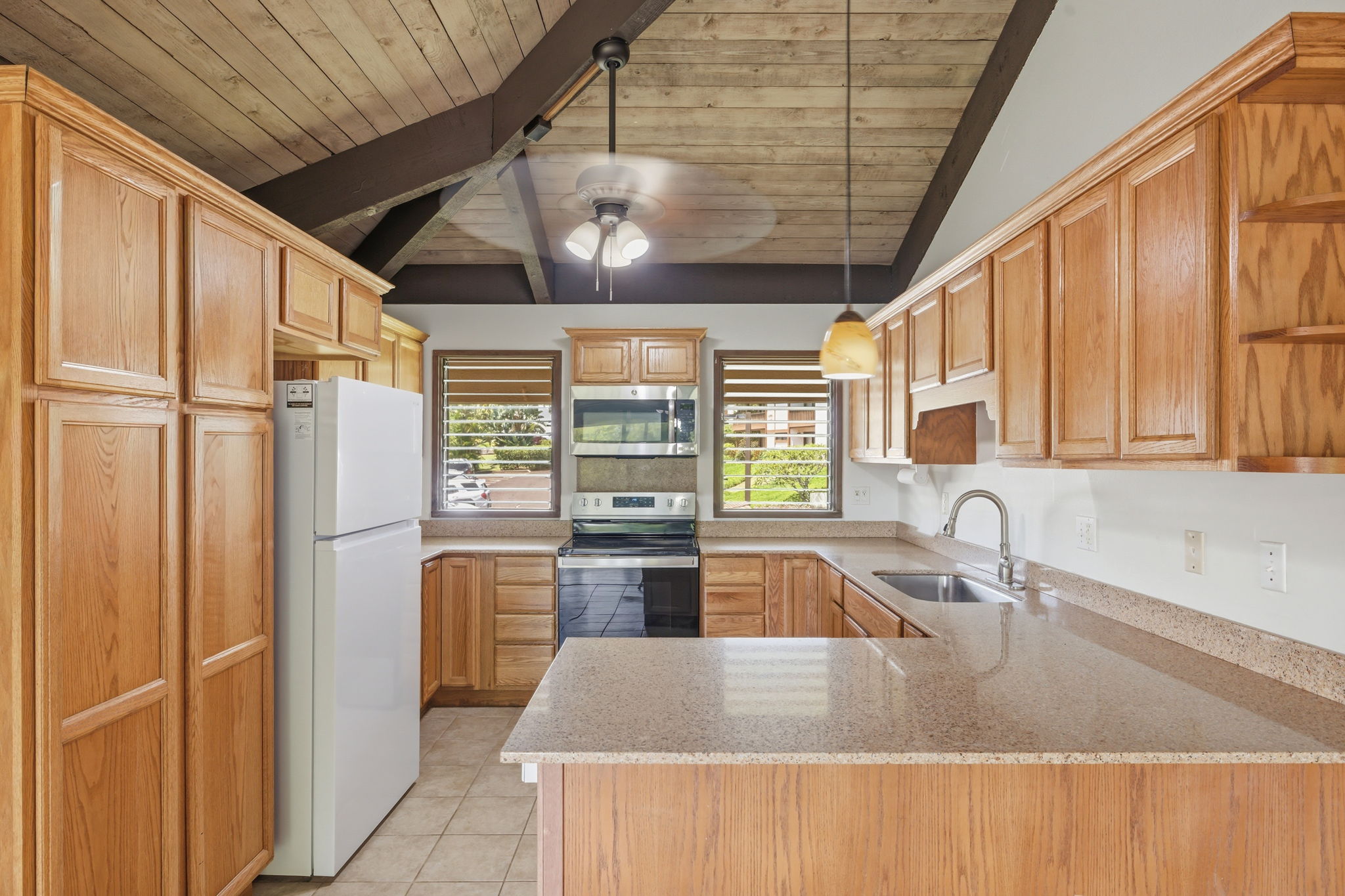 4701 Kawaihau Road, Unit C201 Kapaa, HI 96746 - Photo 8 of 28 a kitchen with stainless steel appliances granite countertop a sink window and cabinets