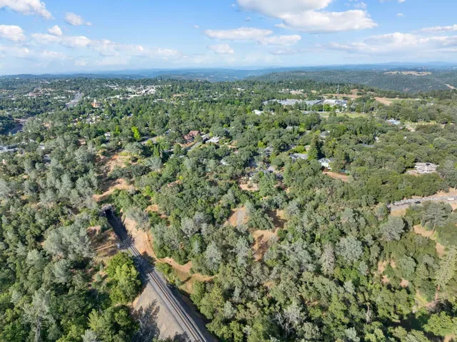 an aerial view of residential houses with outdoor space and trees