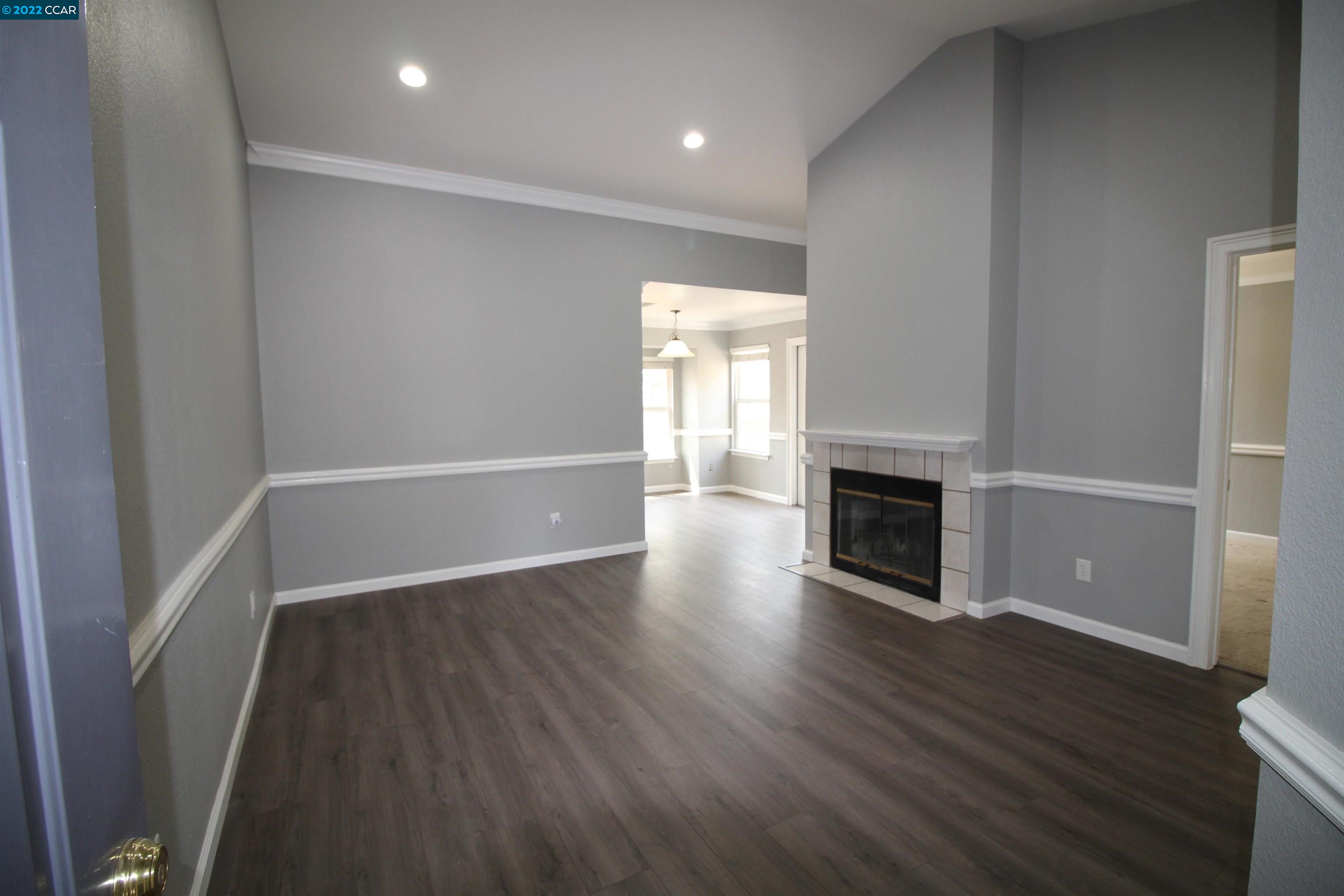 1104 Forest Run Hercules, CA 94547 - Photo 1 of 1 a view of an empty room with wooden floor fireplace and a window