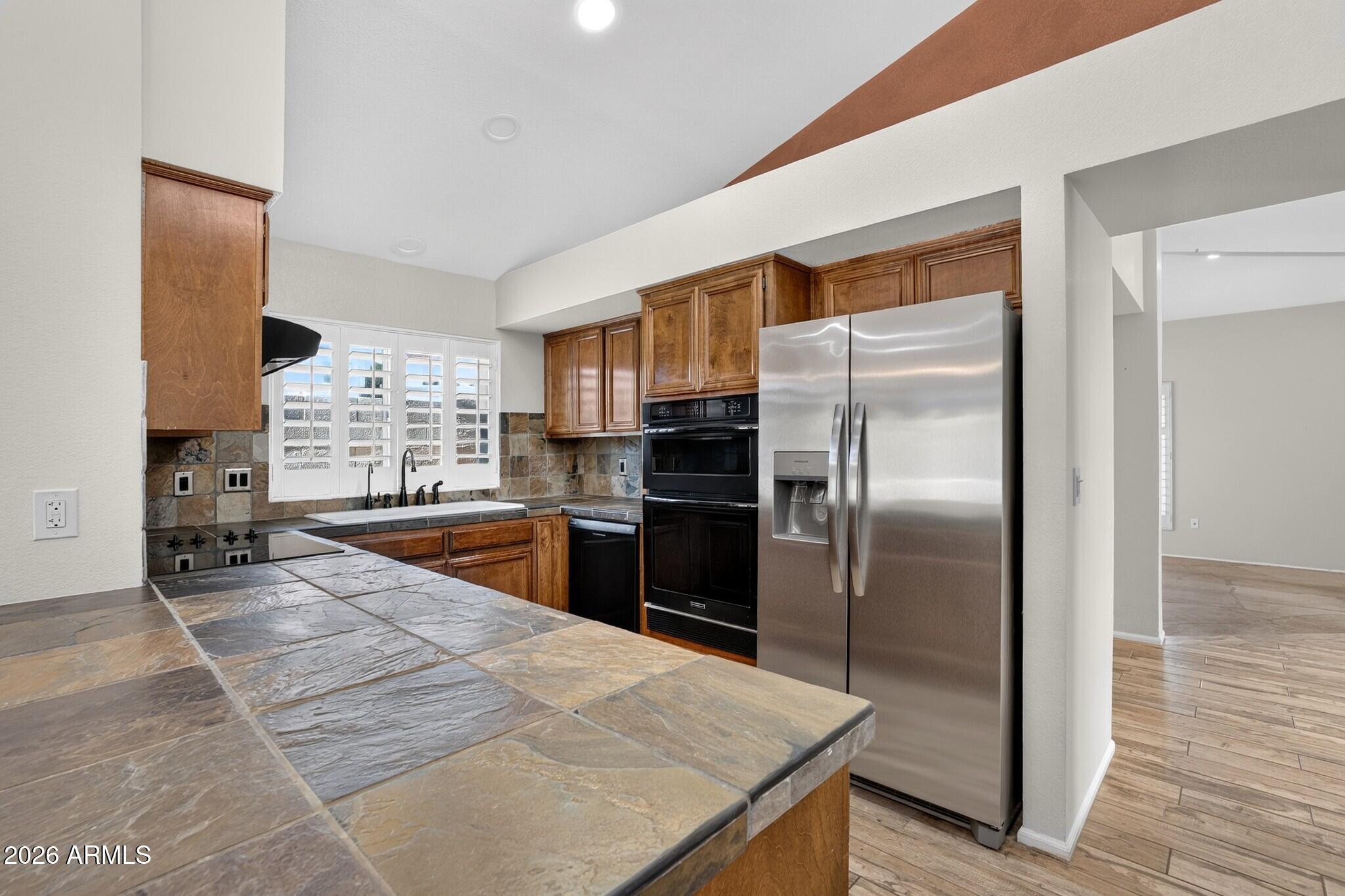 4615 East Monte Way Phoenix, AZ 85044 - Photo 33 of 35 a kitchen with granite countertop a refrigerator and a stove top oven