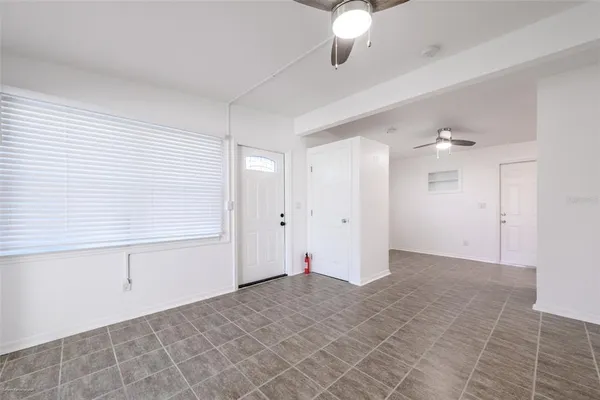 a view of a refrigerator in kitchen and an empty room