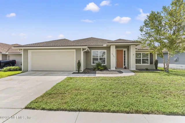 a view of a house with a backyard and a patio