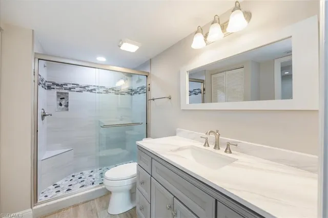 a bathroom with a sink a toilet and shower