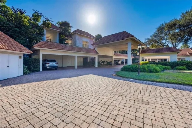 a view of a white house with a small yard and plants