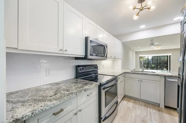 a kitchen with granite countertop a sink stainless steel appliances and cabinets