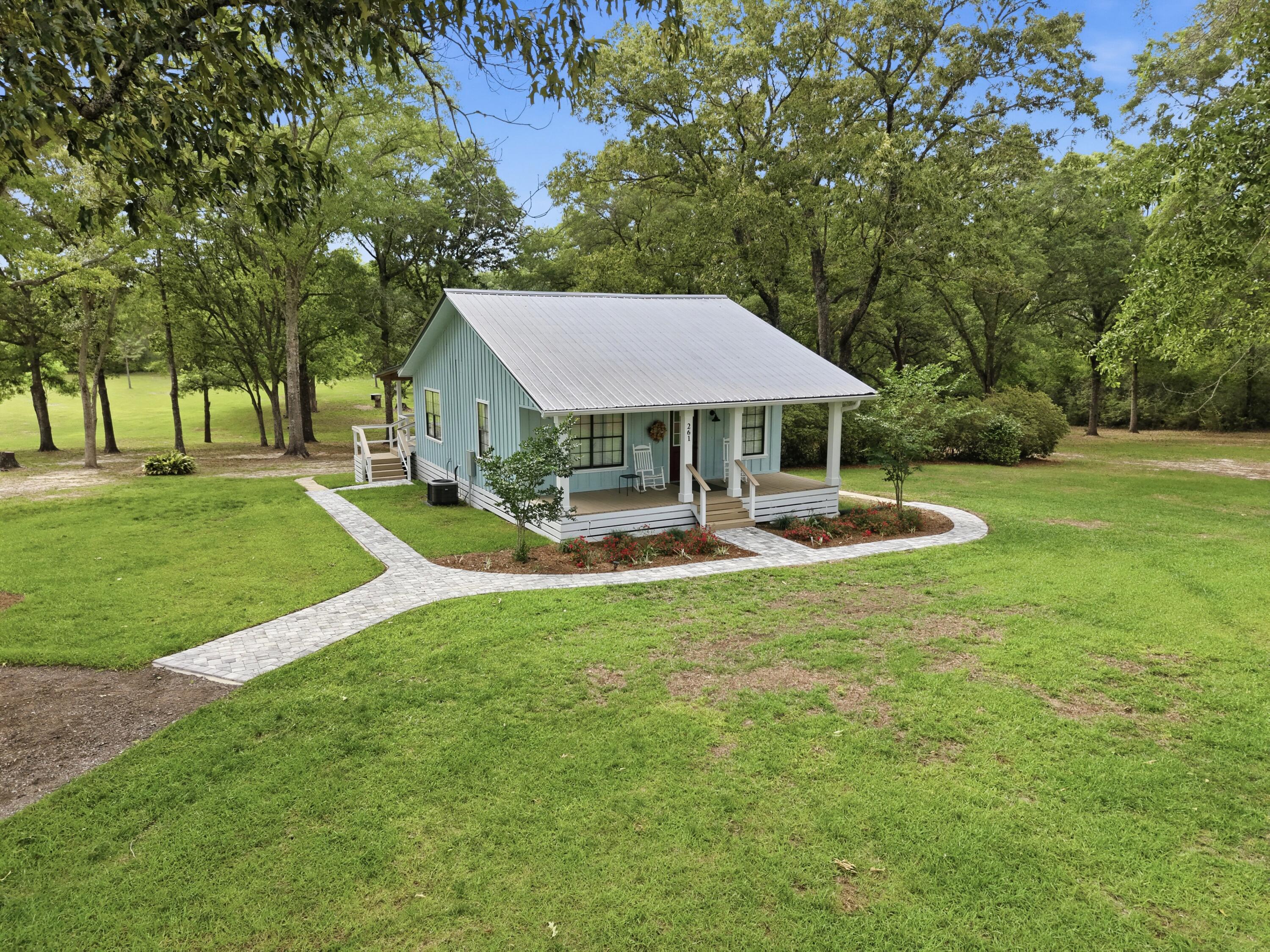 261 Wilkerson Road DeFuniak Springs, FL 32433 - Photo 15 of 76 a view of a patio with a table and chairs under an umbrella