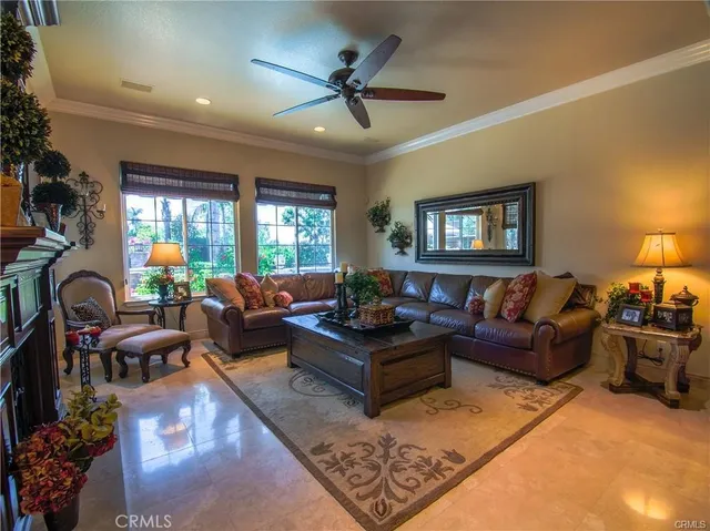 a living room with furniture a wooden floor and a ceiling fan