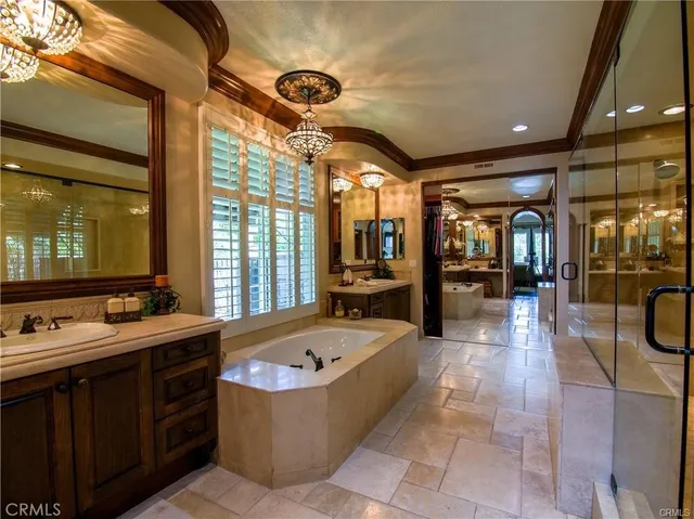 a bathroom with a tub a mirror and shower