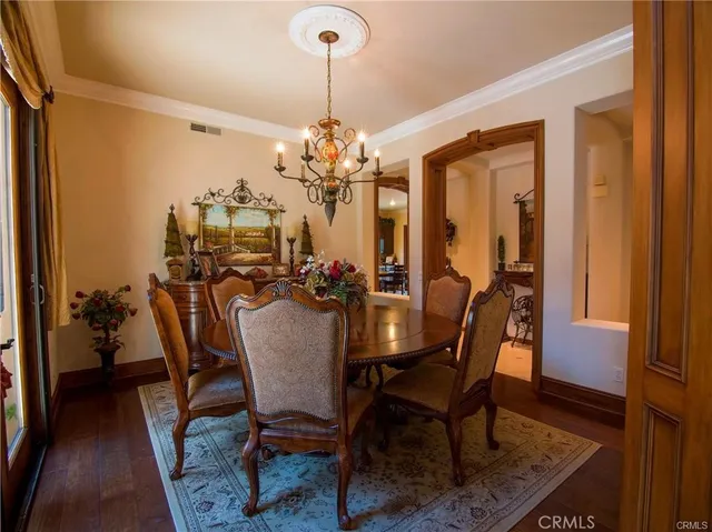 a dining room with furniture a chandelier and wooden floor