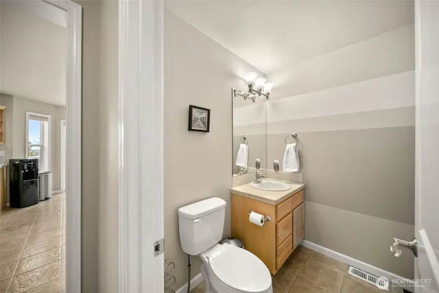 a bathroom with a sink a toilet a mirror and vanity