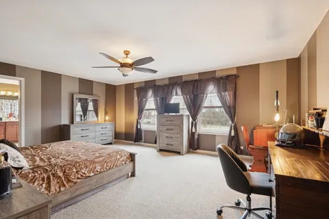 a bedroom with a bed a couch and a window