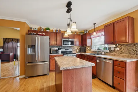 a kitchen with granite countertop a refrigerator and wooden cabinets
