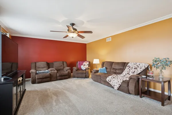 a living room with furniture and a ceiling fan