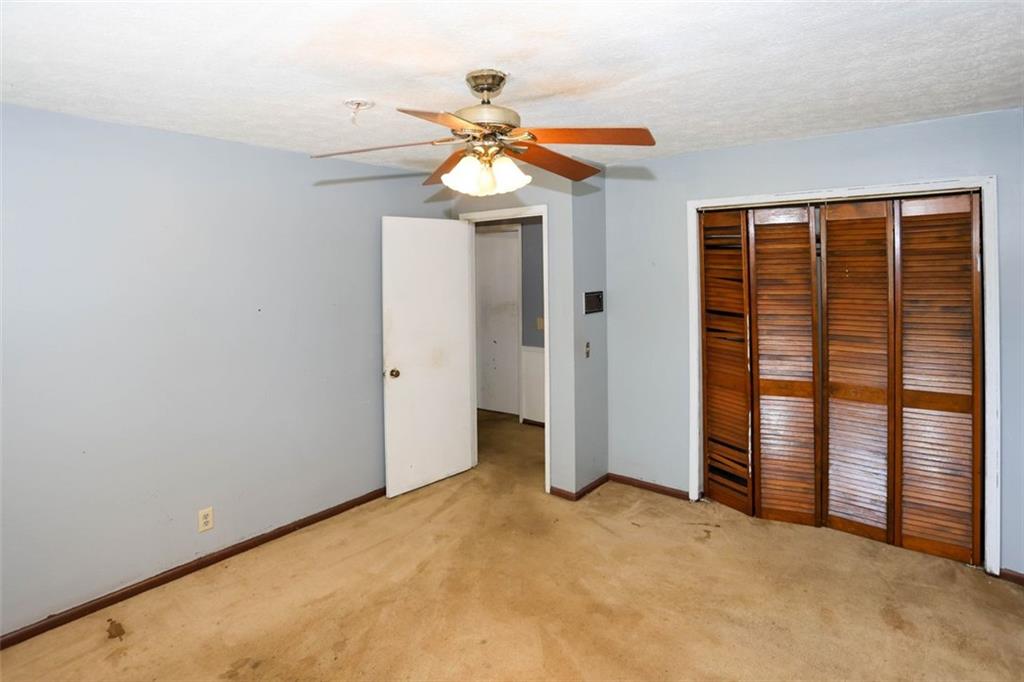 3462 Fairview Road Covington, GA 30016 - Photo 30 of 55 an empty room with chandelier fan and windows