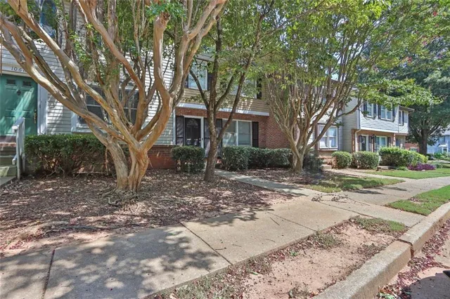 a tree in front of a white house