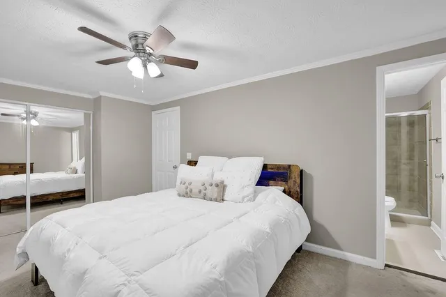 a bedroom with a large bed and a chandelier