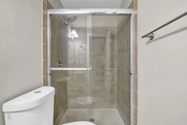 a bathroom with a shower a toilet and sink