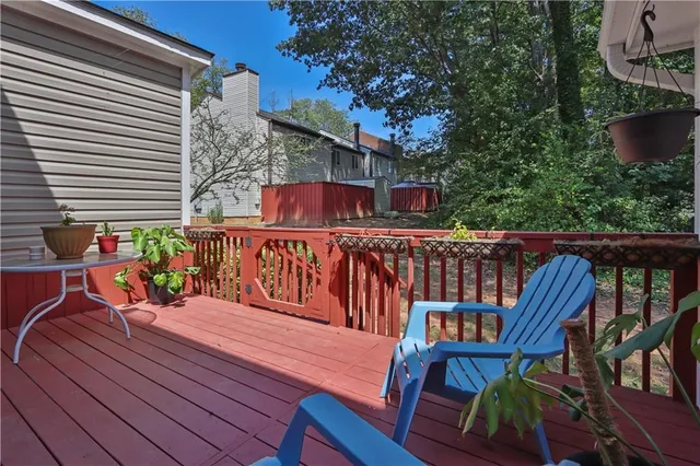 a view of a roof deck with table and chairs with wooden floor and fence