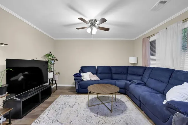 a living room with furniture a flat screen tv and a window